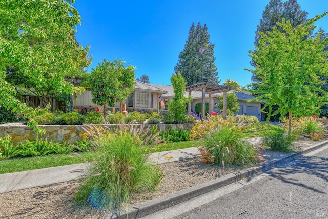 view of front of property featuring an attached garage and a pergola