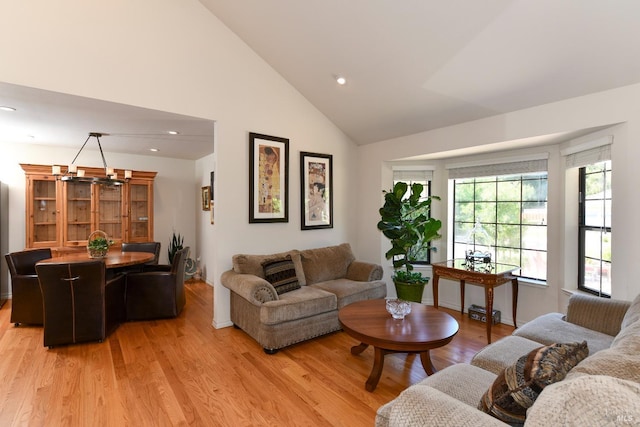 living room featuring high vaulted ceiling, recessed lighting, and light wood-style floors