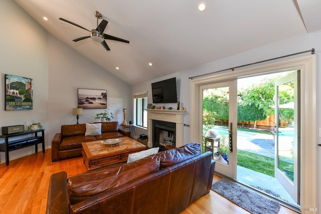 living room with a ceiling fan, light wood-type flooring, a fireplace, high vaulted ceiling, and recessed lighting