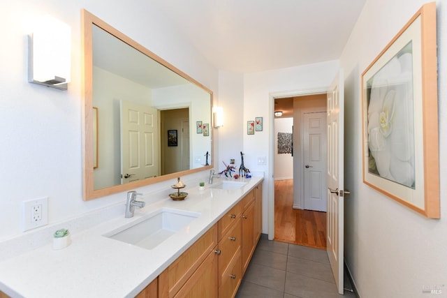 bathroom with tile patterned floors, a sink, and double vanity