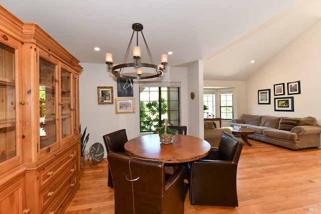 dining space with lofted ceiling, recessed lighting, an inviting chandelier, and light wood-style floors