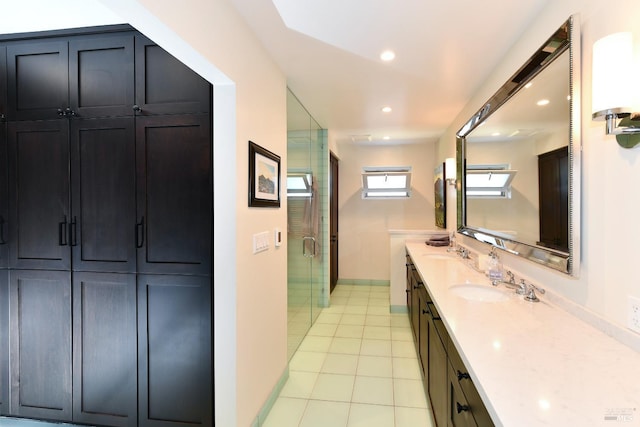 bathroom featuring a shower stall, tile patterned floors, double vanity, and a sink
