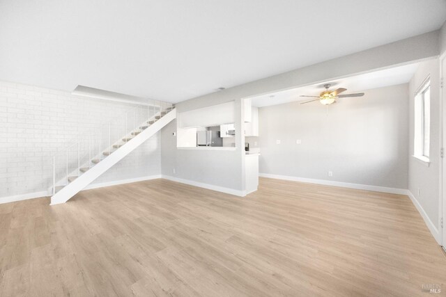 unfurnished living room with ceiling fan and light hardwood / wood-style floors