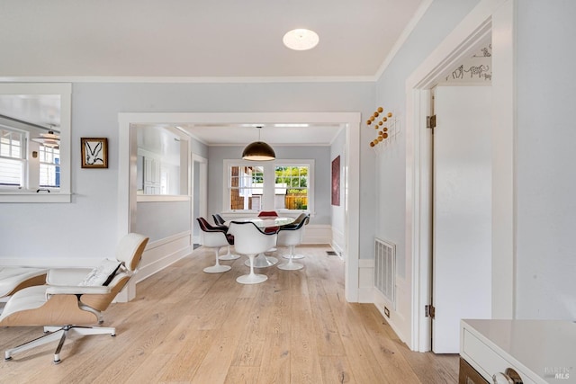 hallway featuring crown molding and light hardwood / wood-style floors