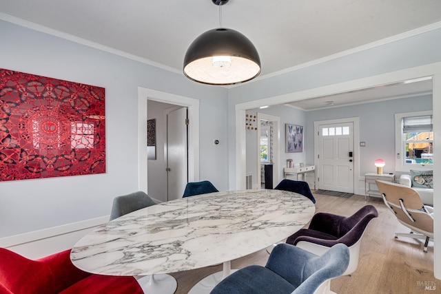 dining room with light hardwood / wood-style flooring and ornamental molding