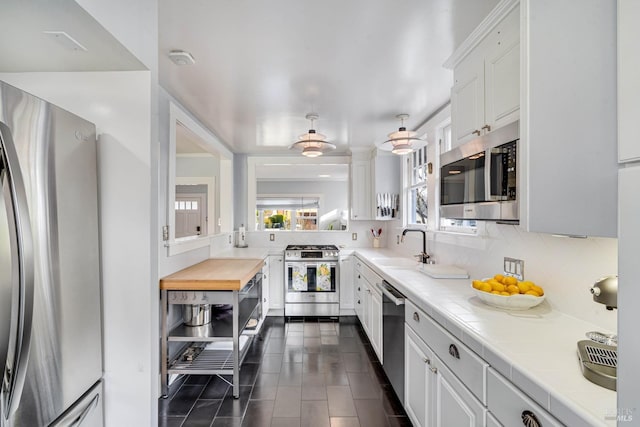 kitchen with white cabinetry, sink, decorative backsplash, and stainless steel appliances