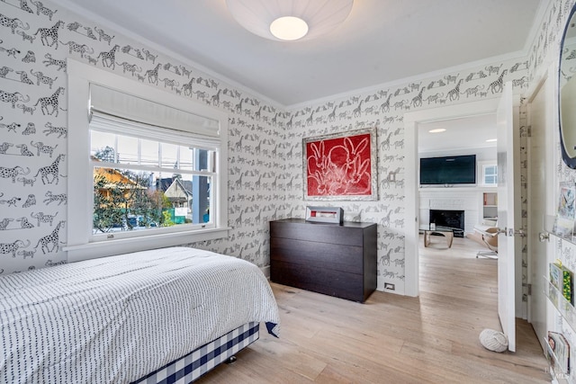 bedroom featuring ornamental molding and light hardwood / wood-style floors