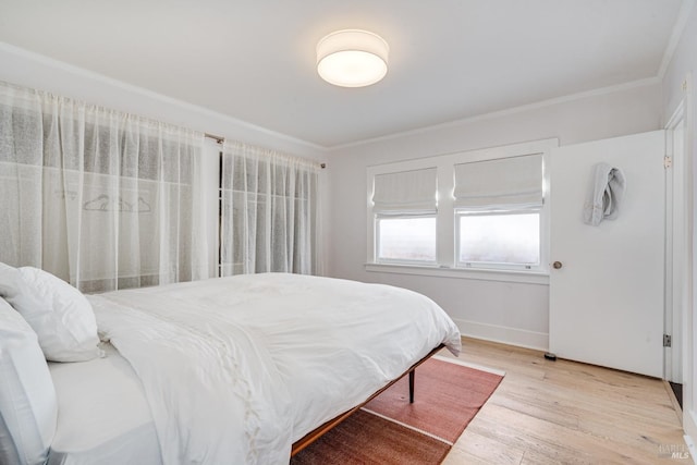 bedroom with crown molding and light hardwood / wood-style flooring