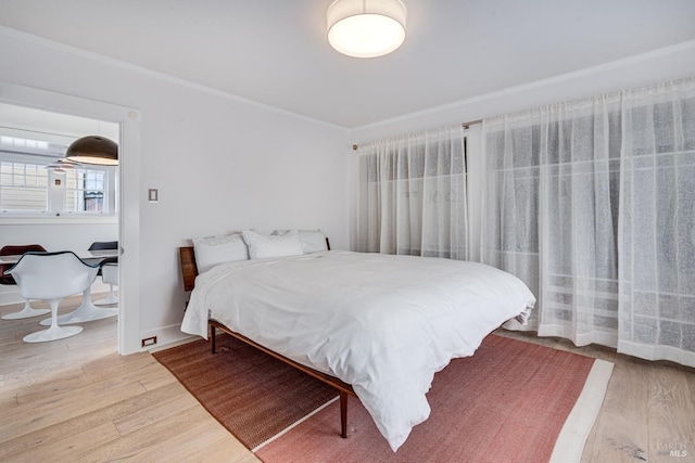 bedroom with hardwood / wood-style flooring and ornamental molding