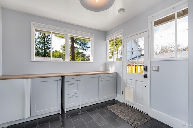 laundry room with dark tile patterned flooring