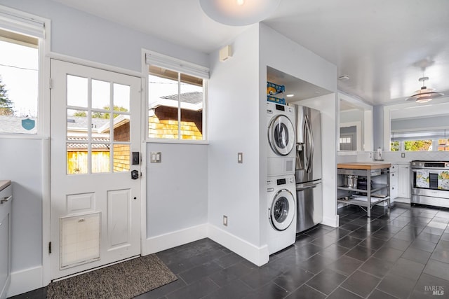 clothes washing area featuring stacked washer / dryer