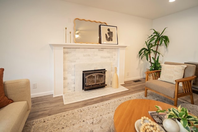 sitting room featuring hardwood / wood-style floors and a brick fireplace