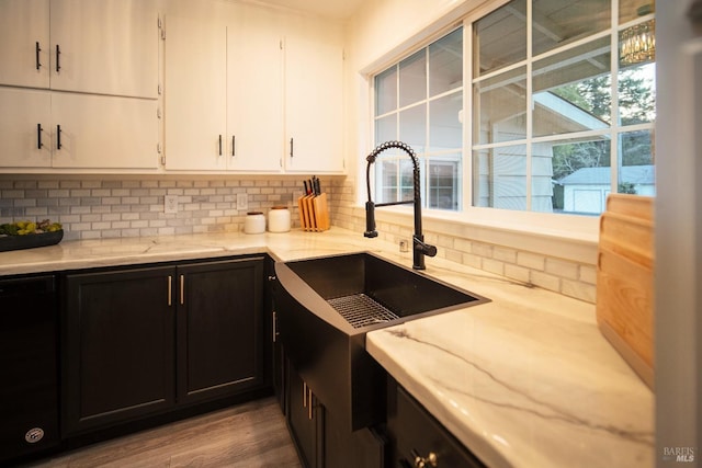 kitchen featuring white cabinetry, backsplash, hardwood / wood-style flooring, and sink