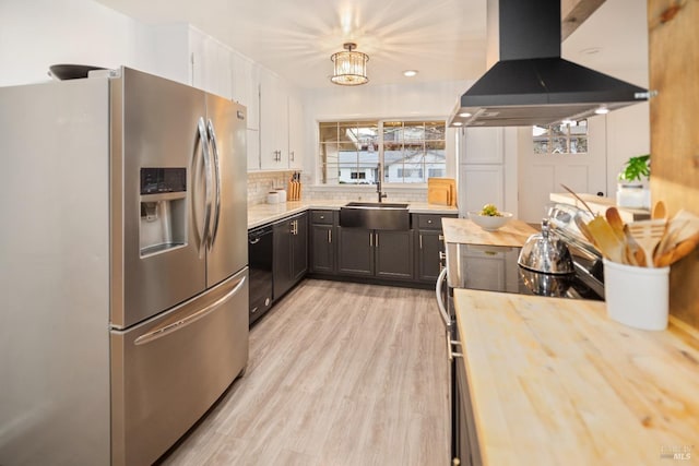 kitchen with electric range oven, island range hood, sink, hanging light fixtures, and stainless steel refrigerator with ice dispenser