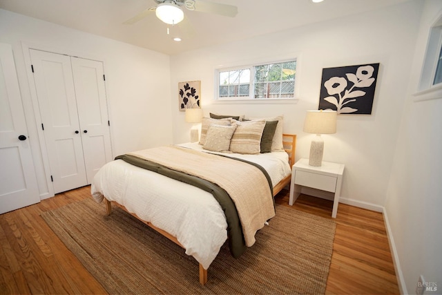 bedroom featuring wood-type flooring, ceiling fan, and a closet