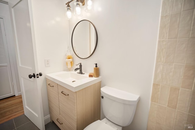 bathroom featuring vanity, tile patterned flooring, and toilet