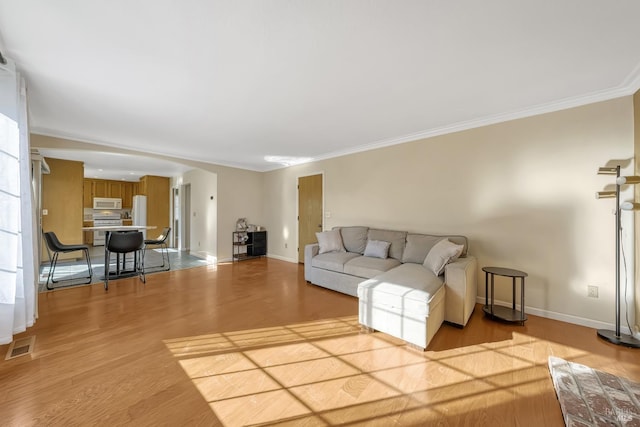 unfurnished living room featuring ornamental molding and light hardwood / wood-style floors