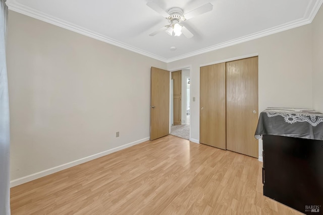 bedroom featuring crown molding, light hardwood / wood-style flooring, a closet, and ceiling fan