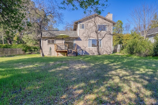 back of house featuring a wooden deck and a lawn