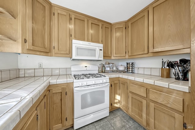 kitchen with light tile patterned flooring, tile countertops, and white appliances