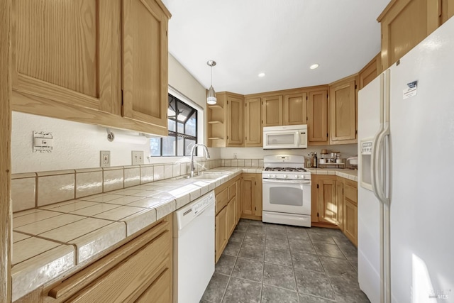 kitchen featuring hanging light fixtures, sink, tile counters, and white appliances