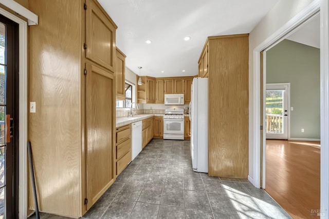 kitchen featuring sink, white appliances, decorative light fixtures, and light brown cabinets