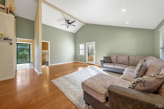 living room featuring ceiling fan, beam ceiling, light hardwood / wood-style flooring, and a wealth of natural light