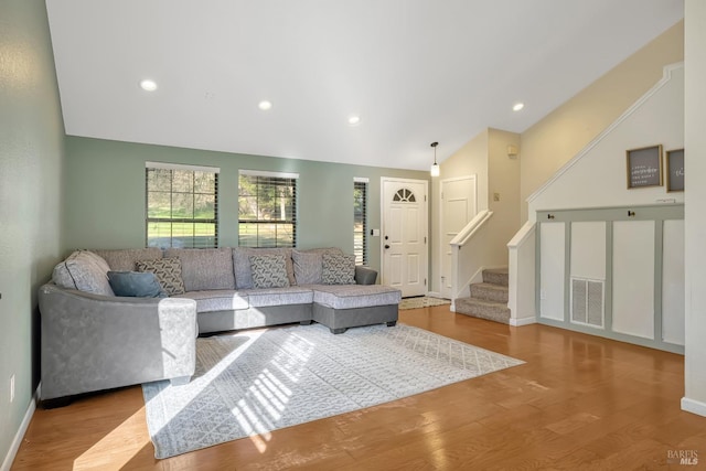 living room featuring vaulted ceiling and light hardwood / wood-style floors