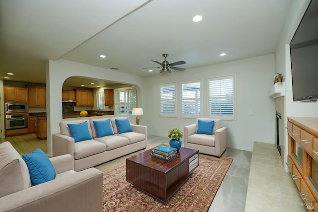 living area featuring arched walkways, a wealth of natural light, and recessed lighting