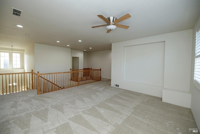 carpeted empty room with a ceiling fan, recessed lighting, and visible vents