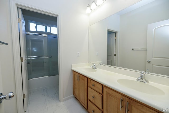 full bathroom with double vanity, marble finish floor, shower / bath combination with glass door, and a sink