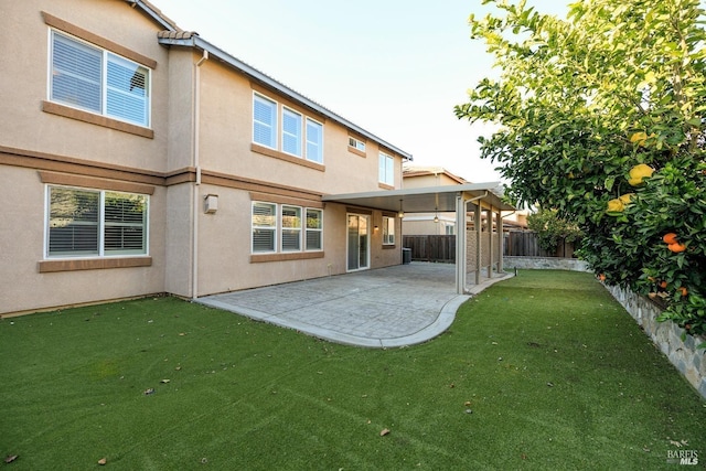 back of property featuring a lawn, a patio area, a fenced backyard, and stucco siding