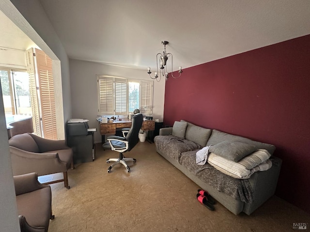 carpeted home office with an inviting chandelier