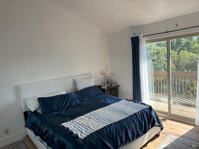 bedroom with access to exterior and hardwood / wood-style floors