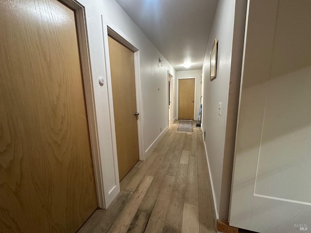 hallway with light hardwood / wood-style flooring