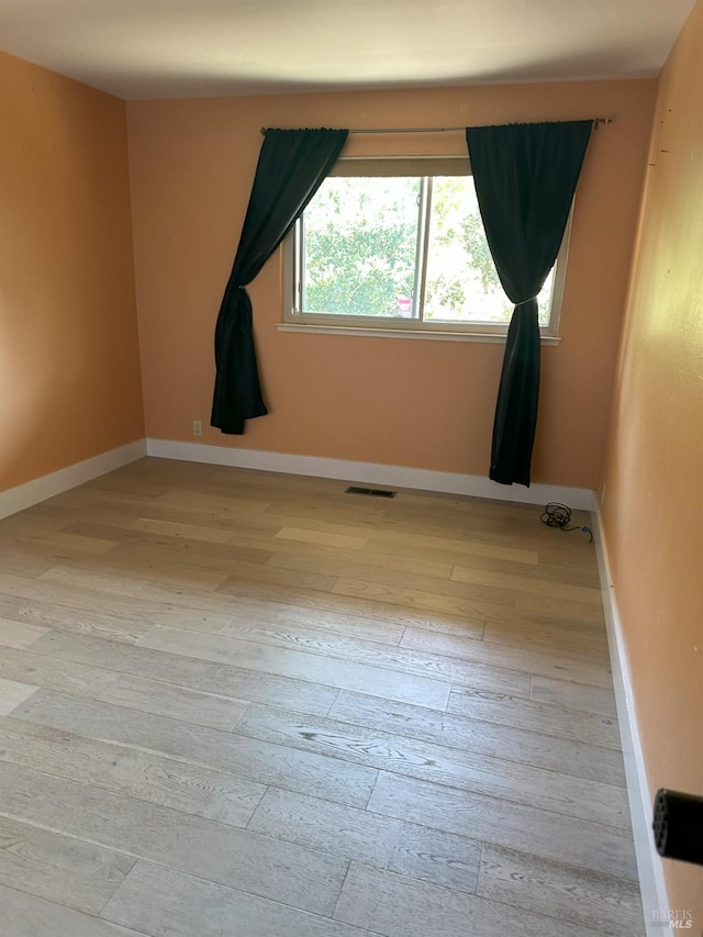 unfurnished room with light wood-type flooring