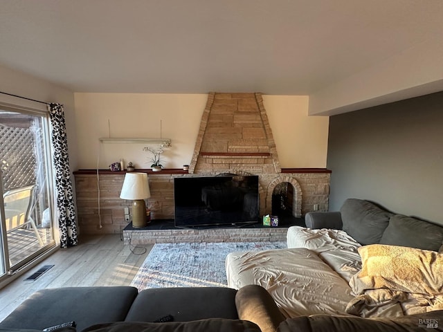 living room with hardwood / wood-style flooring and a large fireplace