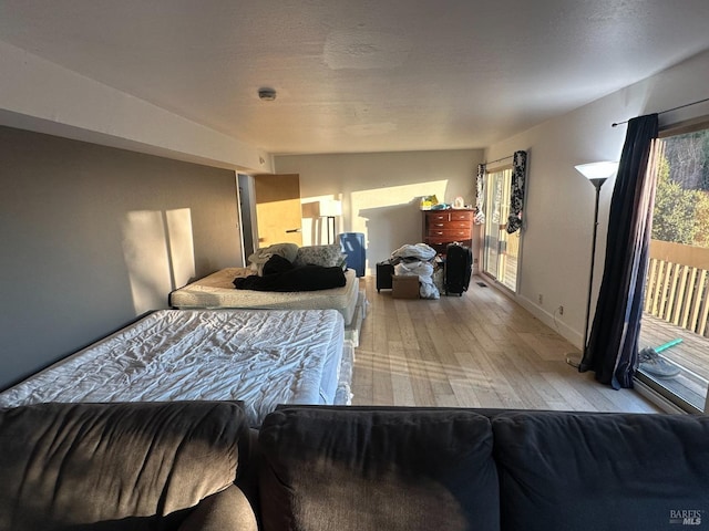 bedroom featuring light hardwood / wood-style flooring, access to outside, and lofted ceiling