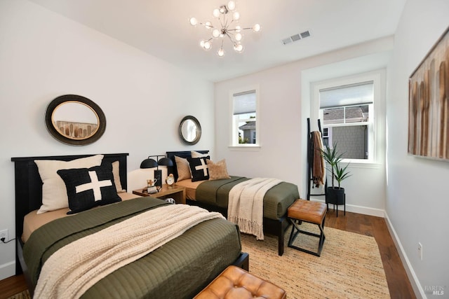 bedroom featuring hardwood / wood-style flooring and an inviting chandelier