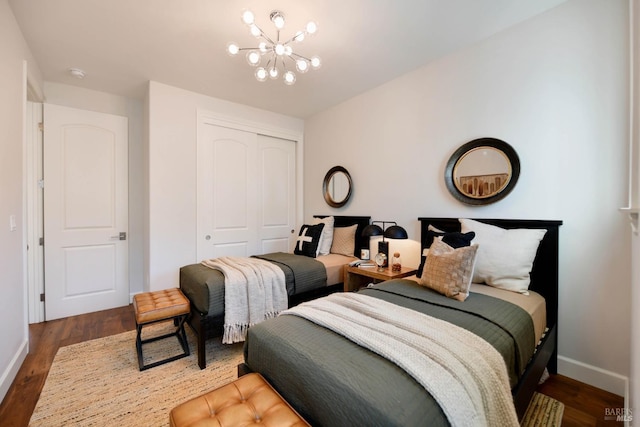 bedroom featuring an inviting chandelier, dark hardwood / wood-style floors, and a closet