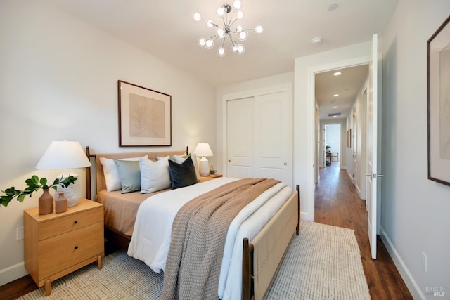 bedroom featuring hardwood / wood-style floors, a notable chandelier, and a closet