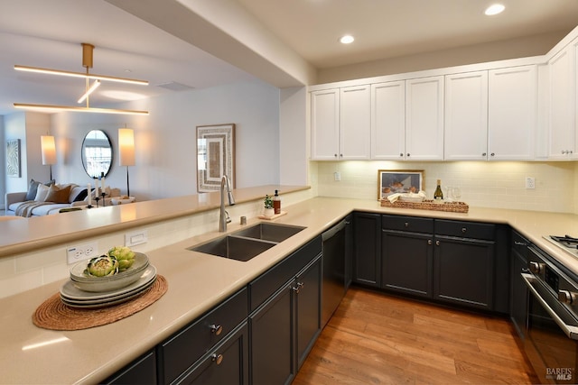 kitchen with sink, white cabinetry, decorative light fixtures, kitchen peninsula, and decorative backsplash