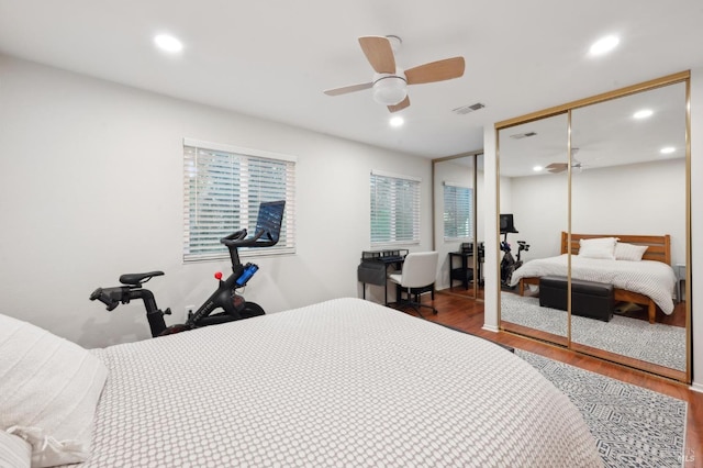 bedroom with multiple windows, hardwood / wood-style floors, a closet, and ceiling fan