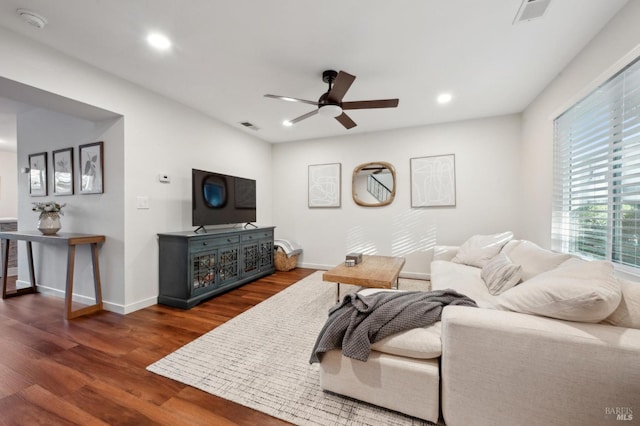 living room featuring ceiling fan and dark hardwood / wood-style floors