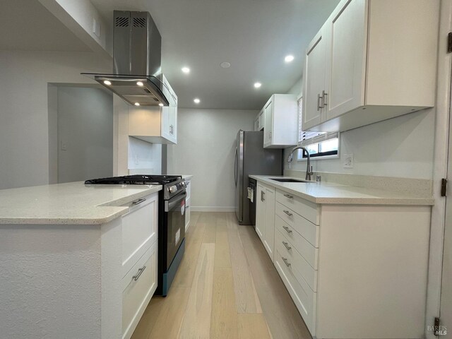 kitchen with pendant lighting, sink, white cabinetry, stainless steel appliances, and light wood-type flooring