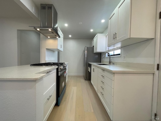 kitchen featuring light stone counters, white cabinets, island range hood, sink, and gas range oven