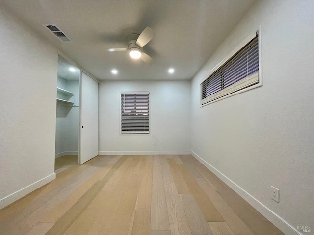 empty room with ceiling fan and light wood-type flooring