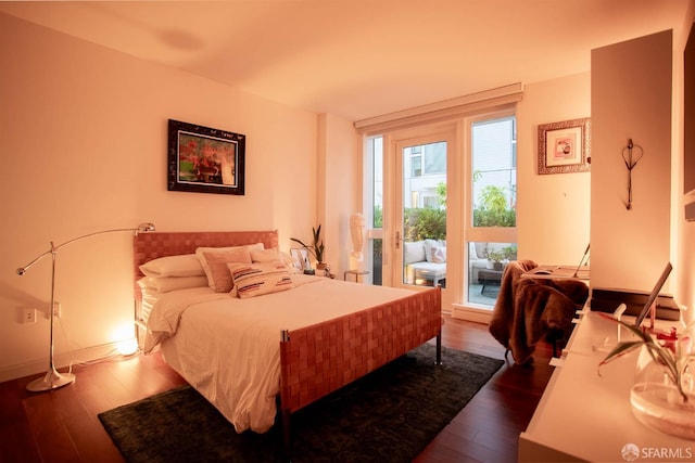 bedroom featuring wood-type flooring and access to outside