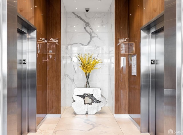 555 Fulton St Unit 214, San Francisco, CA 94102 - corridor featuring elevator, light marble finish floors, and stone wall