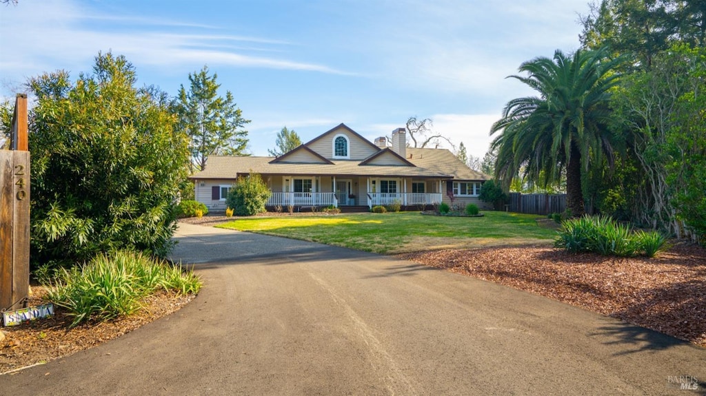 view of front of house featuring covered porch and a front yard